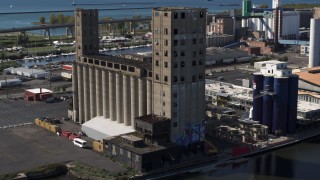 5.7K aerial stock footage orbit a riverfront grain elevator in Buffalo, New York Aerial Stock Footage | DX0002_201_022