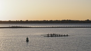 DX0002_203_045 - 5.7K aerial stock footage of orbiting rowboats on Lake Erie at sunset, Buffalo, New York