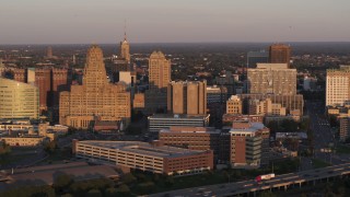 DX0002_204_003 - 5.7K aerial stock footage of a view of city hall beside courthouse and office buildings at sunset, Downtown Buffalo, New York