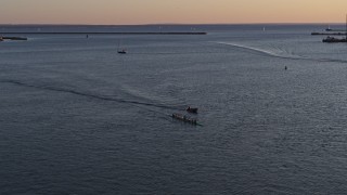 DX0002_204_007 - 5.7K aerial stock footage of rowboat and speedboat on Lake Erie at sunset, Buffalo, New York