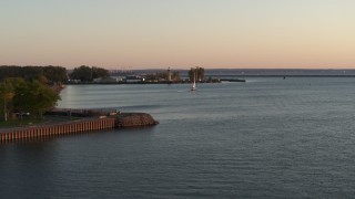 5.7K aerial stock footage approach a sailboat on Lake Erie near lighthouse at sunset, Buffalo, New York Aerial Stock Footage | DX0002_204_014