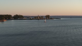 5.7K aerial stock footage flying toward a sailboat on Lake Erie near lighthouse at sunset, Buffalo, New York Aerial Stock Footage | DX0002_204_015