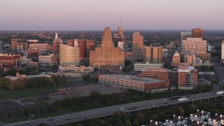 DX0002_204_022 - 5.7K aerial stock footage of city hall and a courthouse by office buildings at sunset, Downtown Buffalo, New York