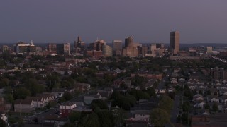 5.7K aerial stock footage of the skyline seen while flying past homes at twilight, Downtown Buffalo, New York Aerial Stock Footage | DX0002_204_038