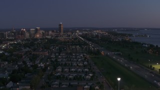 DX0002_204_046 - 5.7K aerial stock footage of skyscraper seen from I-190 and neighborhoods at twilight, Downtown Buffalo, New York