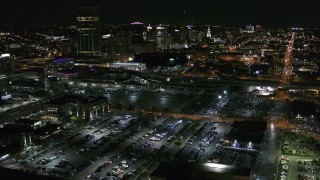 DX0002_205_011 - 5.7K aerial stock footage of flying away from parking lots and skyline at night, Downtown Buffalo, New York