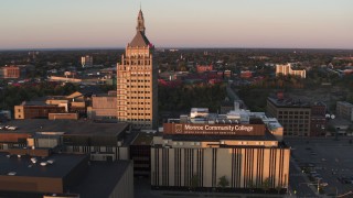 5.7K aerial stock footage of a reverse view of a college and Kodak Tower at sunset, Rochester, New York Aerial Stock Footage | DX0002_209_038