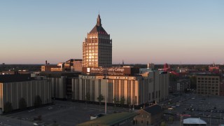 DX0002_209_041 - 5.7K aerial stock footage ascending toward Kodak Tower and a college at sunset, Rochester, New York