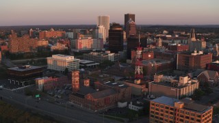 DX0002_209_043 - 5.7K aerial stock footage focus on First Federal Plaza while passing a radio tower at sunset, Downtown Rochester, New York