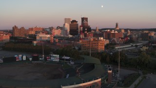 5.7K aerial stock footage reverse view of First Federal Plaza and radio tower at sunset, reveal stadium, Downtown Rochester, New York Aerial Stock Footage | DX0002_209_044