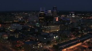 5.7K aerial stock footage descend and fly away from the city's skyline at night, Downtown Rochester, New York Aerial Stock Footage | DX0002_210_023