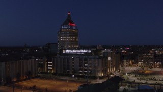 DX0002_210_035 - 5.7K aerial stock footage ascend toward Kodak Tower and college at night, Rochester, New York