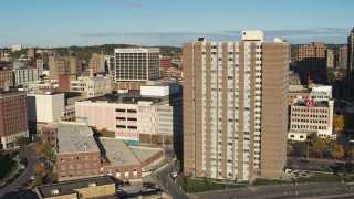 DX0002_213_025 - 5.7K aerial stock footage of passing by office buildings to reveal an apartment high-rise, Downtown Syracuse, New York