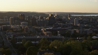 5.7K aerial stock footage of downtown seen while descending by Syracuse University at sunset, New York Aerial Stock Footage | DX0002_214_019