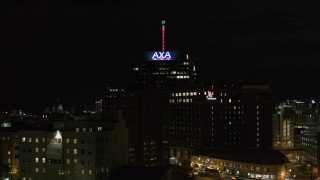 DX0002_215_033 - 5.7K aerial stock footage orbit office tower and hotel at night, reveal apartment complex, Downtown Syracuse, New York