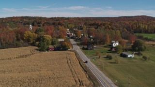 DX0002_217_012 - 5.7K aerial stock footage flyby a country road beside a small town in autumn, Orwell, Vermont