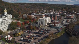 5.7K aerial stock footage ascend over river to reveal government offices and smoke stack by the river, Montpelier, Vermont Aerial Stock Footage | DX0002_218_019