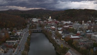 5.7K aerial stock footage of flying by a bridge on the river with a view of the state capitol at sunset, Montpelier, Vermont Aerial Stock Footage | DX0002_220_017