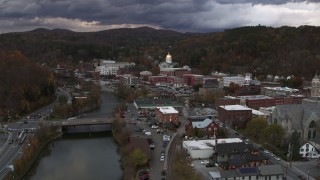 5.7K aerial stock footage of flying over a bridge on the river with a view of the state capitol at sunset, Montpelier, Vermont Aerial Stock Footage | DX0002_220_018