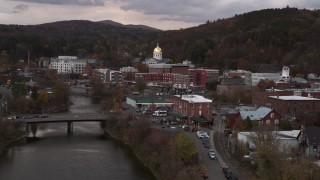 DX0002_220_027 - 5.7K aerial stock footage ascend over a bridge while focused on the capitol dome at sunset, Montpelier, Vermont