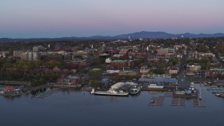 DX0002_225_029 - 5.7K aerial stock footage of orbiting downtown buildings and two marinas at twilight, Burlington, Vermont