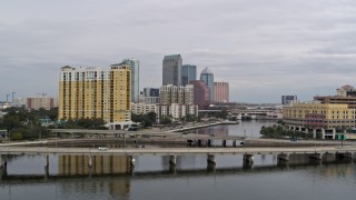 5.7K aerial stock footage fly over a bridge and ascend toward the city skyline behind a condo complex, Downtown Tampa, Florida Aerial Stock Footage | DX0003_229_038