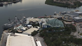 DX0003_230_031 - 5.7K aerial stock footage fly away from and orbit a warship museum and aquarium in Tampa, Florida