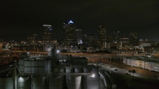 DX0003_232_029 - 5.7K aerial stock footage fly over flour mill to approach skyscrapers at night in Downtown Tampa, Florida