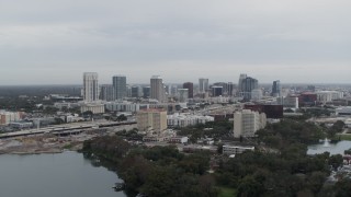 5.7K aerial stock footage of a reverse view of the city's skyline, seen from a lake, Downtown Orlando, Florida Aerial Stock Footage | DX0003_233_003