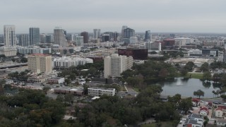 5.7K aerial stock footage orbit office building by a lake, with city's skyline in the background, Downtown Orlando, Florida Aerial Stock Footage | DX0003_233_022