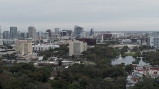 5.7K aerial stock footage ascend from lake toward office building and city's skyline, Downtown Orlando, Florida Aerial Stock Footage | DX0003_233_024