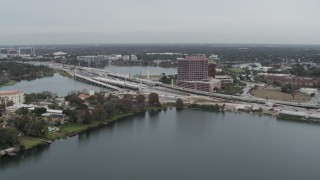 5.7K aerial stock footage of light freeway traffic and office building by a lake in Orlando, Florida Aerial Stock Footage | DX0003_233_026