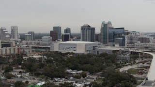 5.7K aerial stock footage descend past Amway Center arena and city skyline, Downtown Orlando, Florida Aerial Stock Footage | DX0003_234_030