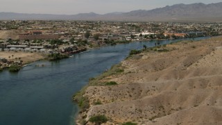 4K aerial stock footage follow the Colorado River to approach riverfront homes and apartments in Bullhead City, Arizona Aerial Stock Footage | FG0001_000010