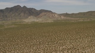 FG0001_000025 - 4K aerial stock footage pan across Dead Mountains Wilderness Area, seen from flat Mojave Desert plain in Laughlin, Nevada