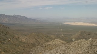 4K aerial stock footage fly over mountains in the Mojave Desert to reveal a desert valley in San Bernardino County, California Aerial Stock Footage | FG0001_000049