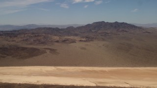 4K aerial stock footage pan across Mojave Desert mountains near a dry lake in San Bernardino County, California Aerial Stock Footage | FG0001_000063