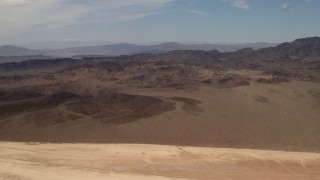 4K aerial stock footage pan across Mojave Desert mountains, seen from a dry lake in San Bernardino County, California Aerial Stock Footage | FG0001_000064