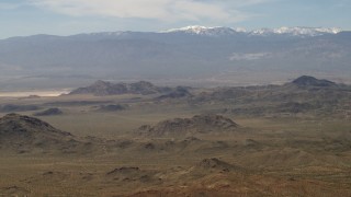 4K aerial stock footage of the San Bernardino Mountains with snow behind Mojave Desert mountains, San Bernardino County, California Aerial Stock Footage | FG0001_000114