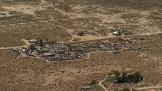 4K aerial stock footage of passing an auto junkyard in the Mojave Desert, San Bernardino County, California Aerial Stock Footage | FG0001_000122