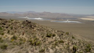 FG0001_000171 - 4K aerial stock footage fly over a desert mountain to reveal the Ivanpah Solar Electric Generating System in California