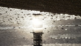 4K aerial stock footage of a close-up view and orbit of a glowing power tower boiler at the Ivanpah Solar Electric Generating System in California Aerial Stock Footage | FG0001_000209