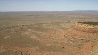 FG0001_000226 - 4K aerial stock footage tilt from desert vegetation to reveal and approach the edge of a mesa in the Arizona Desert