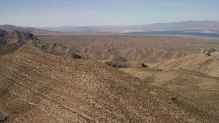 FG0001_000262 - 4K aerial stock footage flyby steep-sloped mountain ridges in the Nevada Desert near rolling hills and Lake Mead