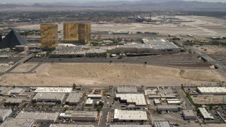 FG0001_000351 - 4K aerial stock footage tilt from an open dirt lot beside I-15 with light traffic in Las Vegas, Nevada to casino resorts on the Strip