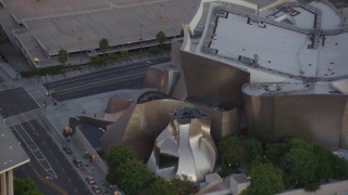 HDA06_72 - HD stock footage aerial video orbit Walt Disney Concert Hall, tilt to reveal skyscrapers in Downtown Los Angeles, California at twilight