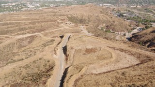 HDA07_19 - HD stock footage aerial video follow a road toward construction sites in Santa Clarita Valley, California