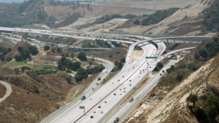 HDA07_29 - HD stock footage aerial video follow the 14 freeway to reveal the interchange at Newhall Pass, Santa Clarita, California