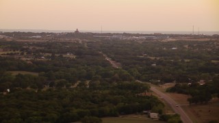 HD aerial stock footage video of rural homes, road near factory at sunset in Decatur, Texas Aerial Stock Footage | HDA12_172