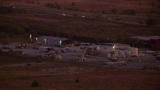 HDA12_178 - HD stock footage aerial video of a train passing an industrial  building near a highway, Decatur, Texas, night